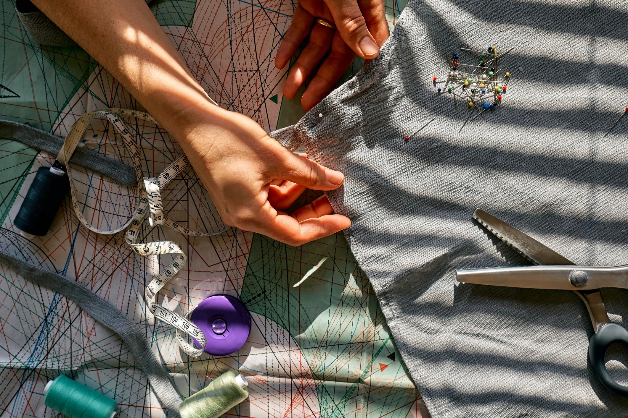 Woman is sketching pattern on a linen fabric