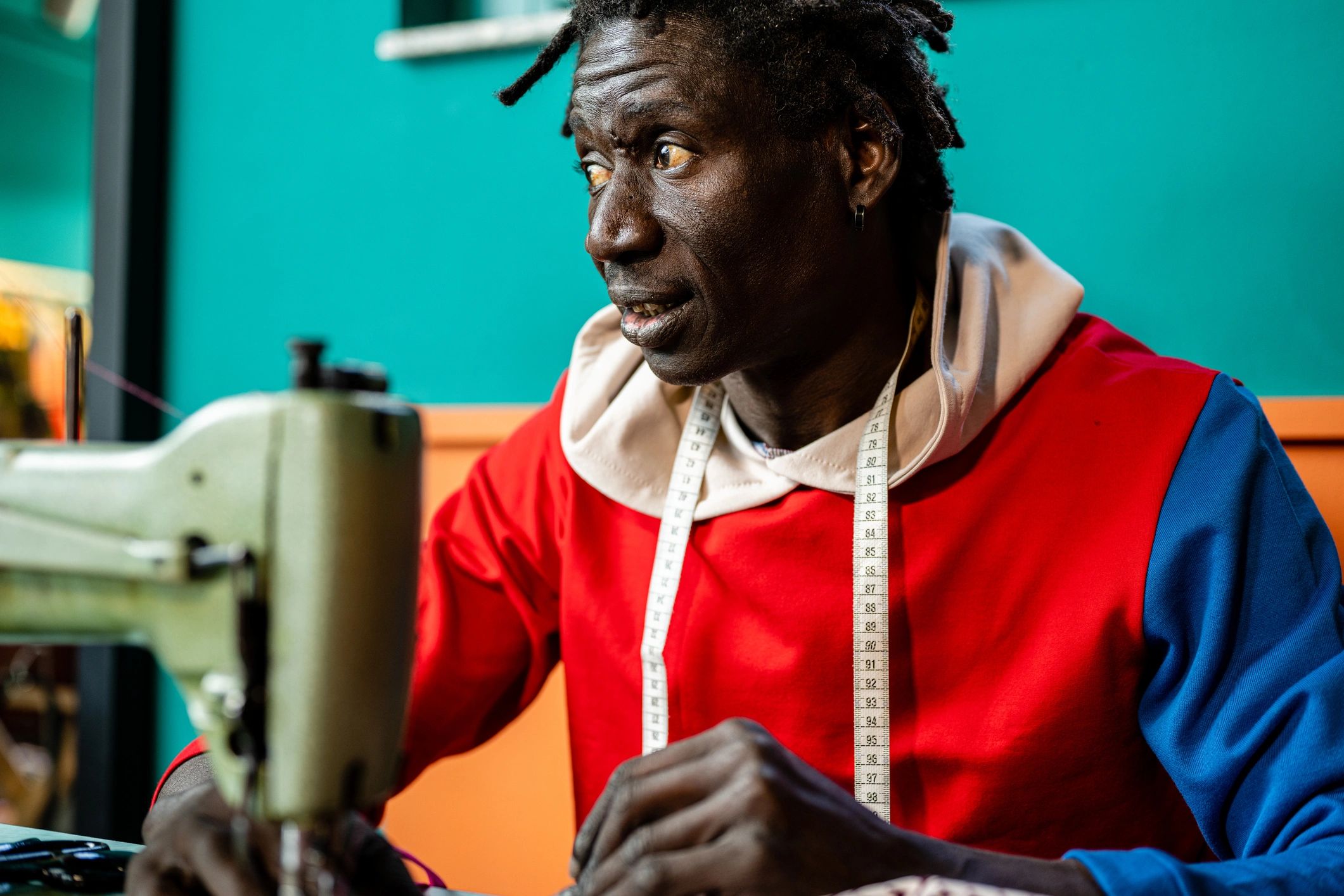 African adult tailor at work, artisan clothing manufacturer